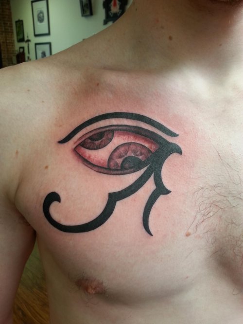 Black Tribal And Horus Eye Tattoo On Man Chest